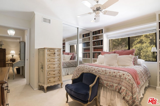 bedroom featuring light carpet, ceiling fan with notable chandelier, crown molding, and a closet