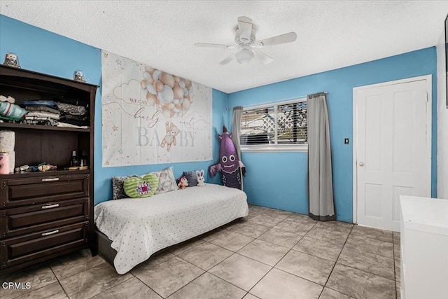 bedroom with ceiling fan and a textured ceiling