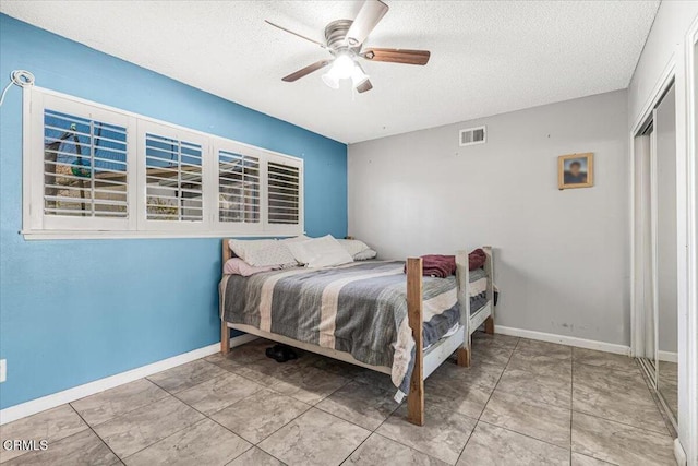 bedroom with ceiling fan, a closet, and a textured ceiling