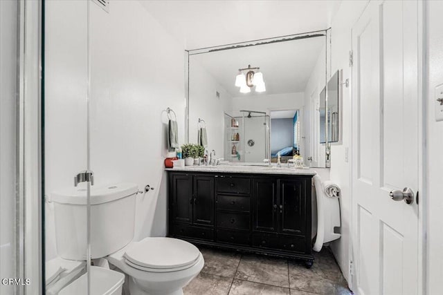 bathroom featuring an inviting chandelier, tile patterned floors, vanity, and toilet