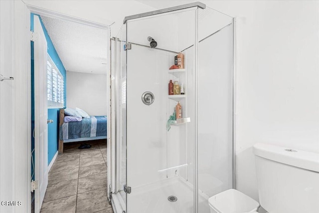 bathroom featuring tile patterned floors, a shower with door, and toilet