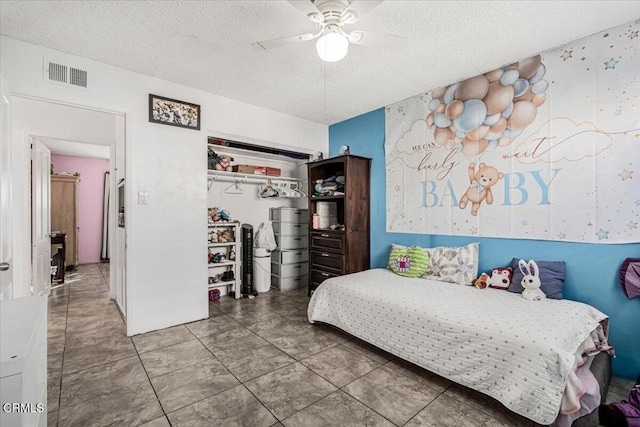 bedroom with ceiling fan, a textured ceiling, and a closet