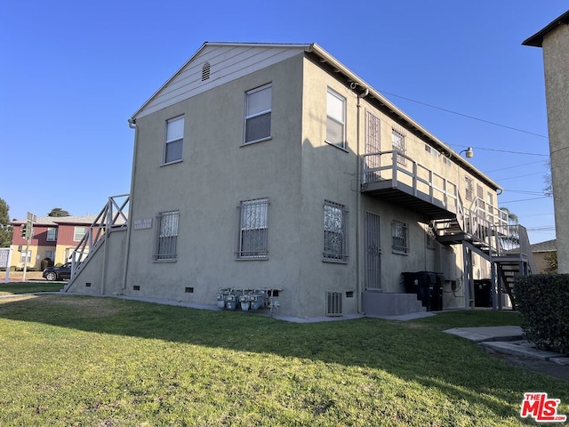 view of property exterior with a balcony and a yard