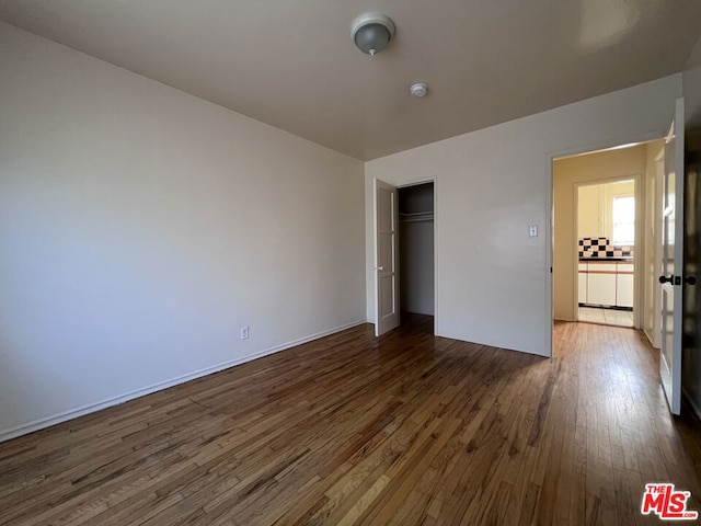 unfurnished bedroom featuring a closet and dark hardwood / wood-style floors