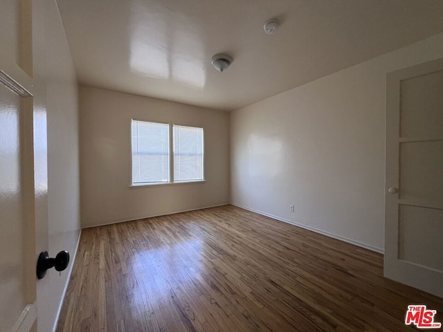 spare room featuring wood-type flooring