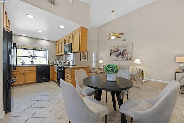 dining room featuring a towering ceiling, ceiling fan, and light tile patterned flooring