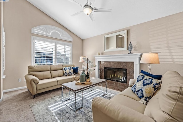 living room featuring ceiling fan, lofted ceiling, a high end fireplace, and light colored carpet