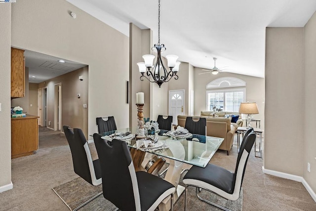 carpeted dining room with lofted ceiling and ceiling fan with notable chandelier