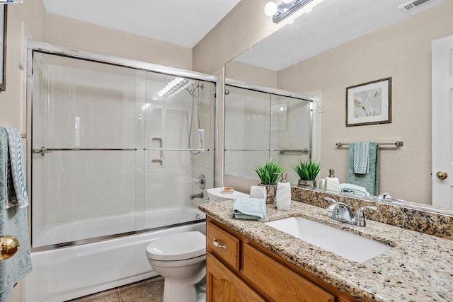 full bathroom featuring vanity, tile patterned flooring, toilet, and combined bath / shower with glass door