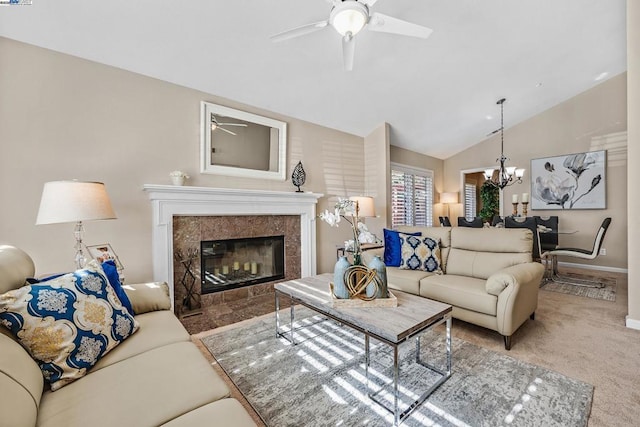 carpeted living room featuring a tiled fireplace, ceiling fan with notable chandelier, and vaulted ceiling