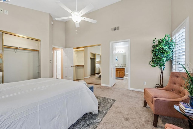 bedroom featuring high vaulted ceiling, ensuite bath, light colored carpet, and ceiling fan