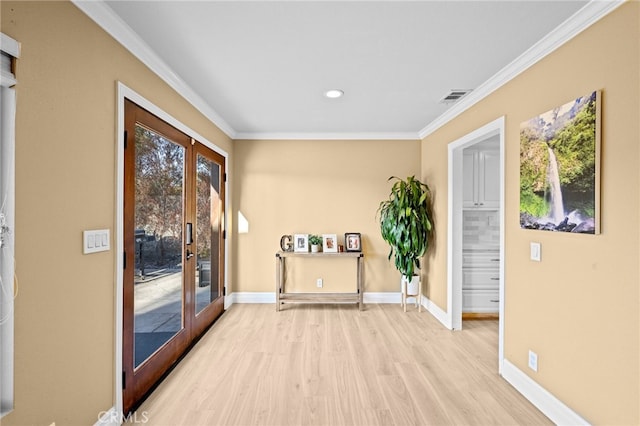 doorway featuring french doors, ornamental molding, and light hardwood / wood-style floors