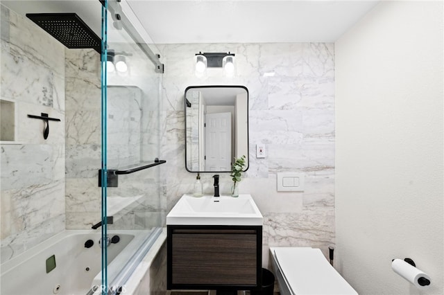 full bathroom featuring vanity, toilet, combined bath / shower with glass door, and tile walls