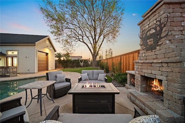 patio terrace at dusk featuring an outdoor living space with a fireplace