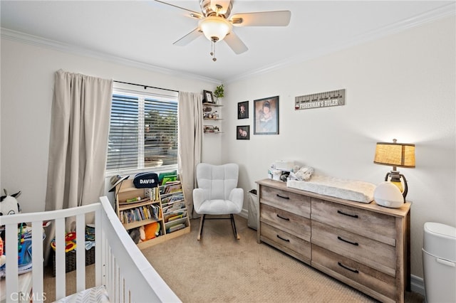 bedroom with crown molding, light colored carpet, a nursery area, and ceiling fan