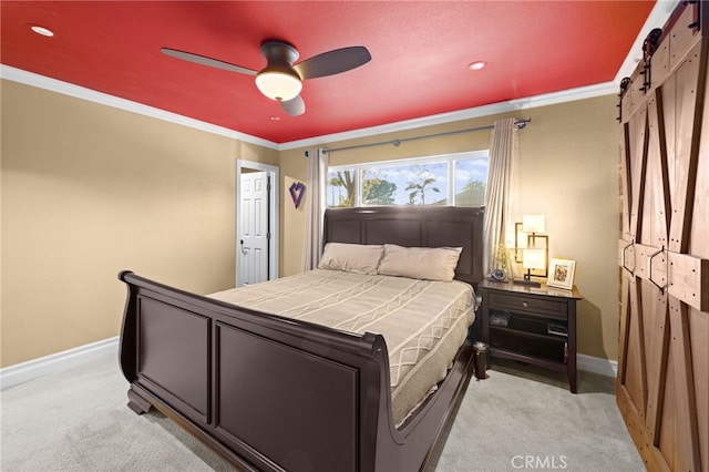 carpeted bedroom with ornamental molding, a barn door, and ceiling fan