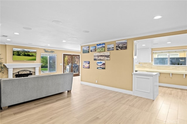 living room featuring crown molding and light hardwood / wood-style floors