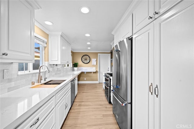 kitchen with sink, backsplash, high quality appliances, ornamental molding, and white cabinets