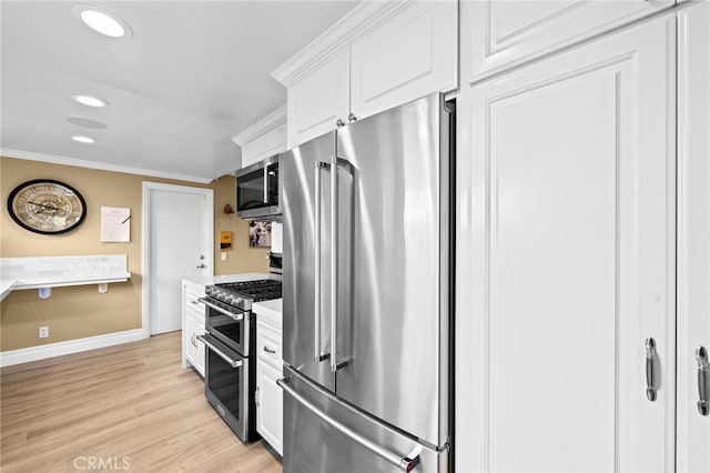 kitchen featuring ornamental molding, stainless steel appliances, light hardwood / wood-style floors, and white cabinets