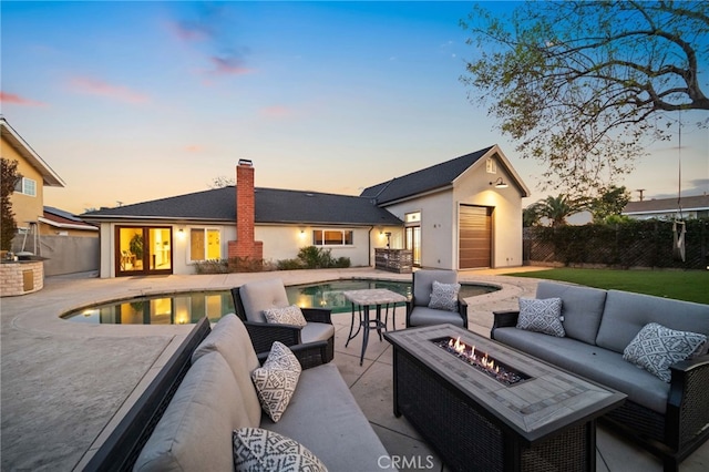 exterior space featuring a fenced in pool and an outdoor living space with a fire pit