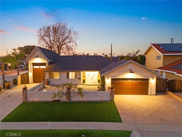 view of front of home with a garage and a lawn