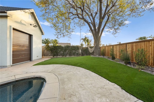 view of yard with a fenced in pool and a patio