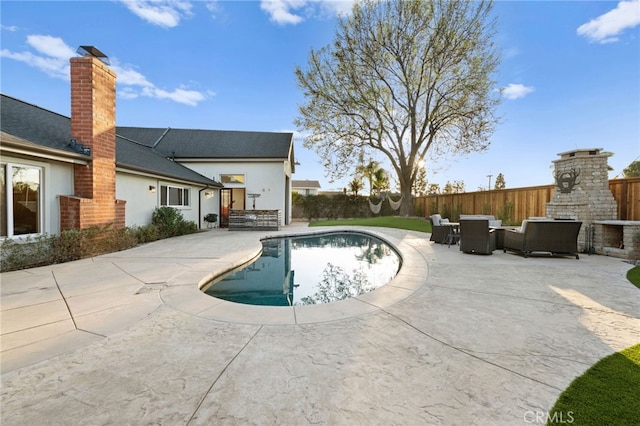 view of swimming pool with a fireplace and a patio