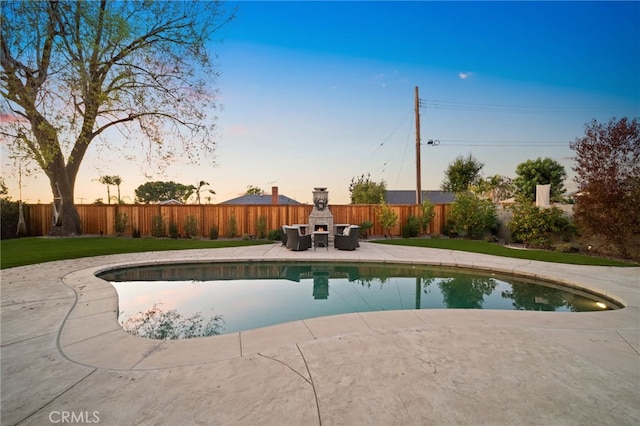 pool at dusk with a patio