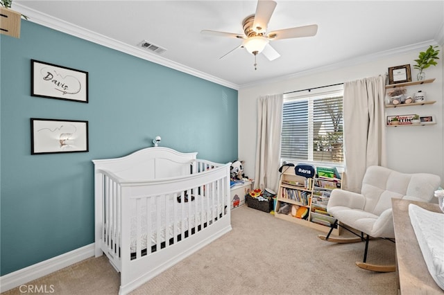 carpeted bedroom featuring a crib, crown molding, and ceiling fan