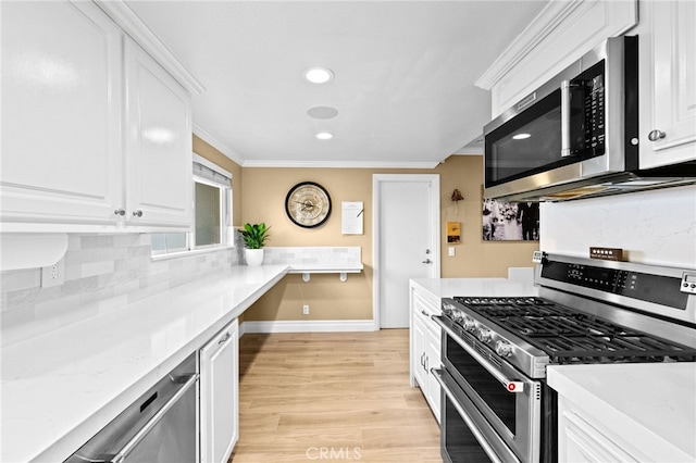 kitchen with crown molding, appliances with stainless steel finishes, and white cabinets