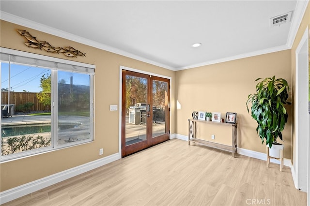 interior space featuring crown molding, light hardwood / wood-style floors, and french doors