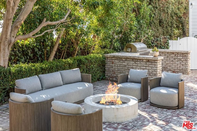 view of patio / terrace featuring a grill, an outdoor kitchen, and an outdoor fire pit