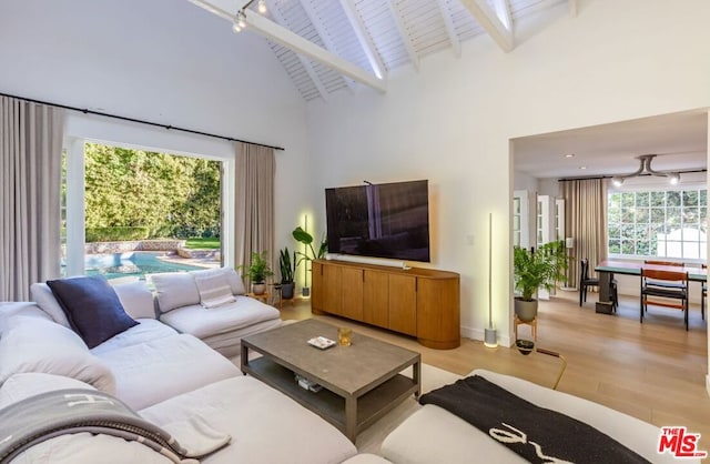 living room featuring beamed ceiling, high vaulted ceiling, and light hardwood / wood-style floors