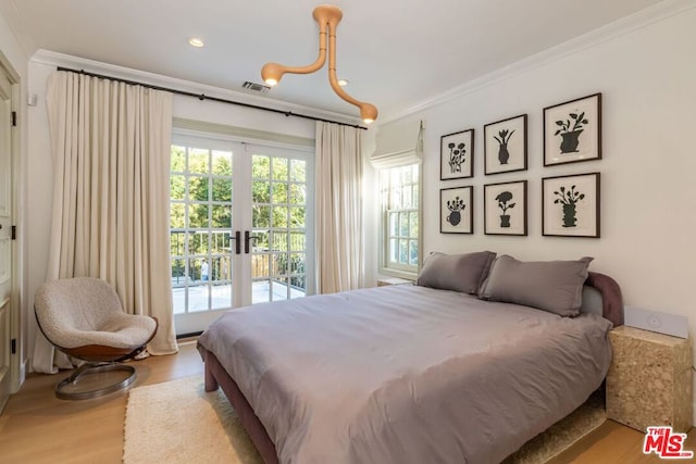 bedroom featuring multiple windows, access to outside, and light wood-type flooring