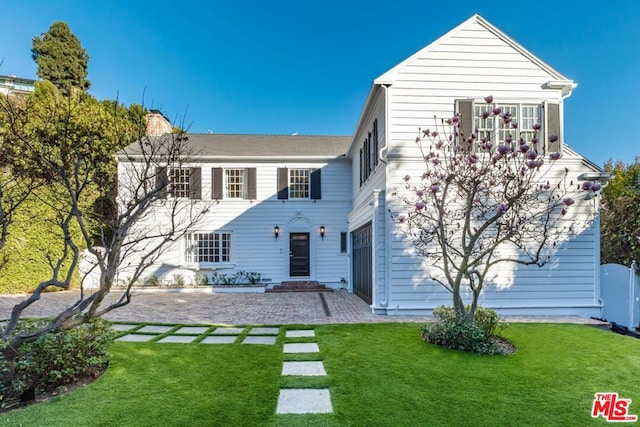 back of property with a yard and a patio