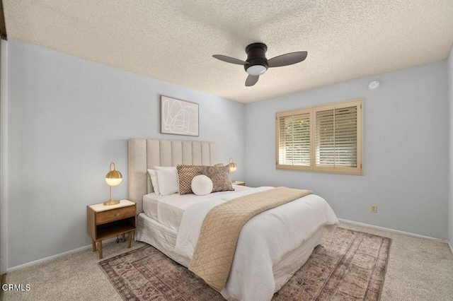 carpeted bedroom with ceiling fan and a textured ceiling