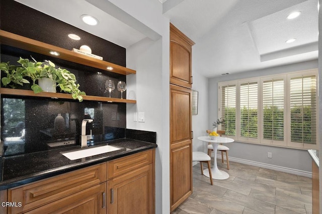 bar with sink and dark stone counters