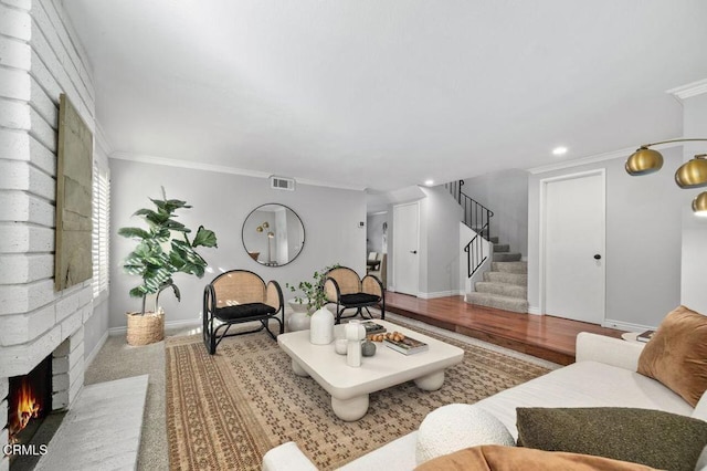 living room featuring ornamental molding and a brick fireplace