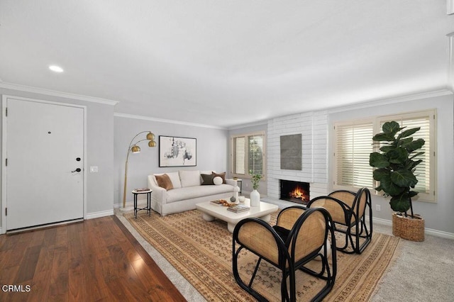 living room featuring ornamental molding, a fireplace, wood-type flooring, and a wealth of natural light