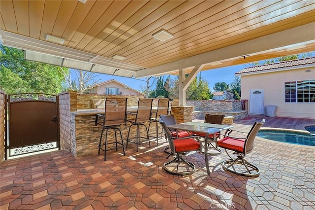 view of patio featuring a swimming pool and a bar