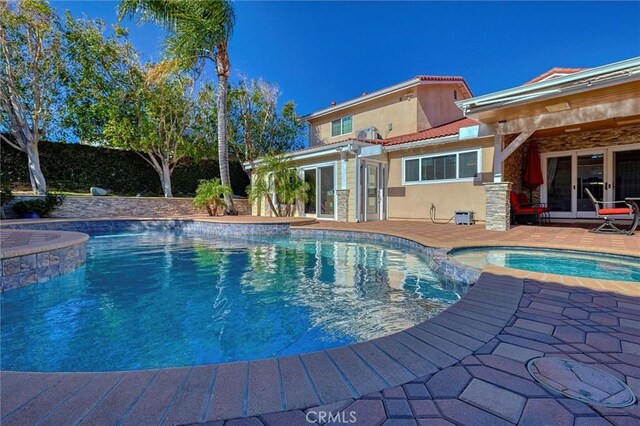 view of pool with an in ground hot tub and a patio area