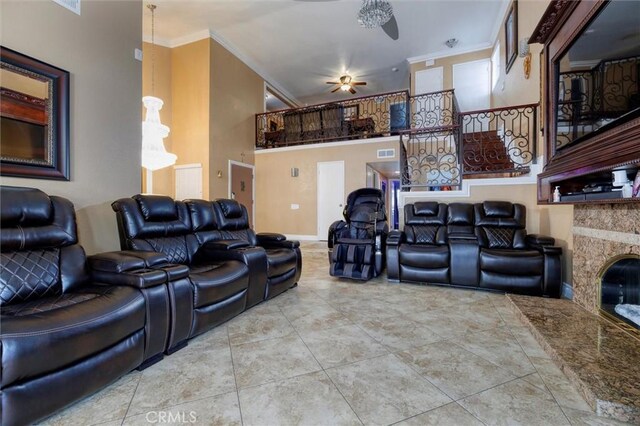 tiled cinema room featuring crown molding, ceiling fan, and a premium fireplace