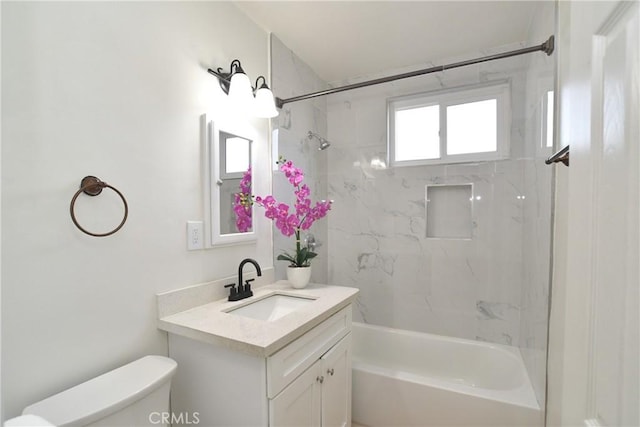 full bathroom with tiled shower / bath, vanity, and toilet