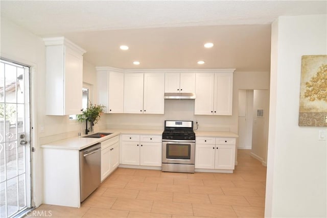 kitchen featuring appliances with stainless steel finishes, sink, and white cabinets