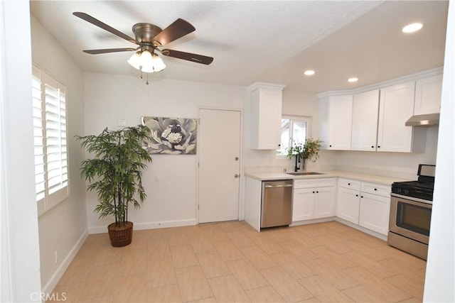 kitchen featuring ceiling fan, stainless steel appliances, sink, and white cabinets