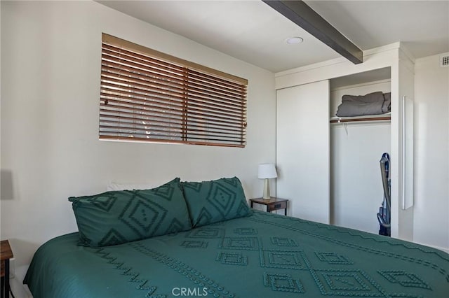 bedroom with a closet and beamed ceiling