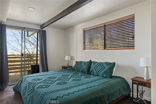 carpeted bedroom with beamed ceiling