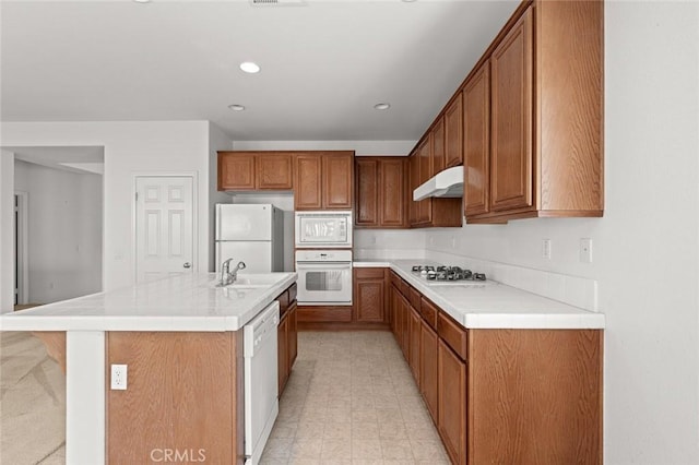 kitchen with sink, white appliances, an island with sink, and a kitchen bar