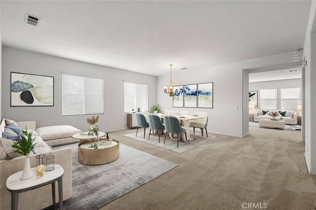 carpeted living room with a notable chandelier