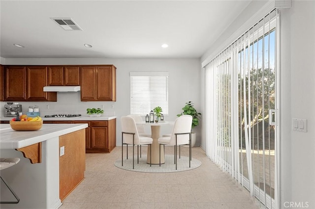 kitchen with tile counters, a breakfast bar, and gas stovetop